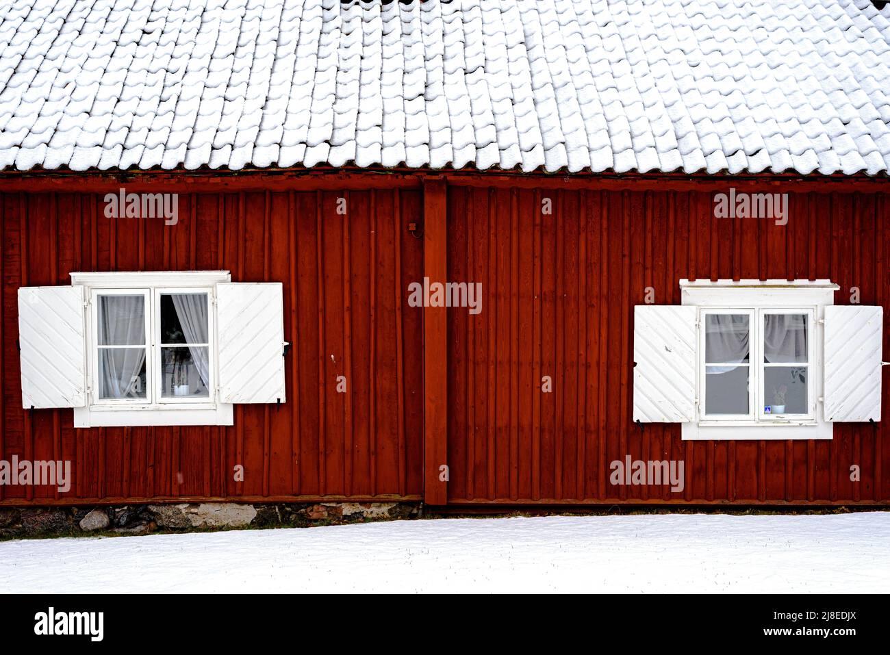 Traditionelles schwedisches rotes Holzhaus. Winter, Dach mit Schnee bedeckt Stockfoto