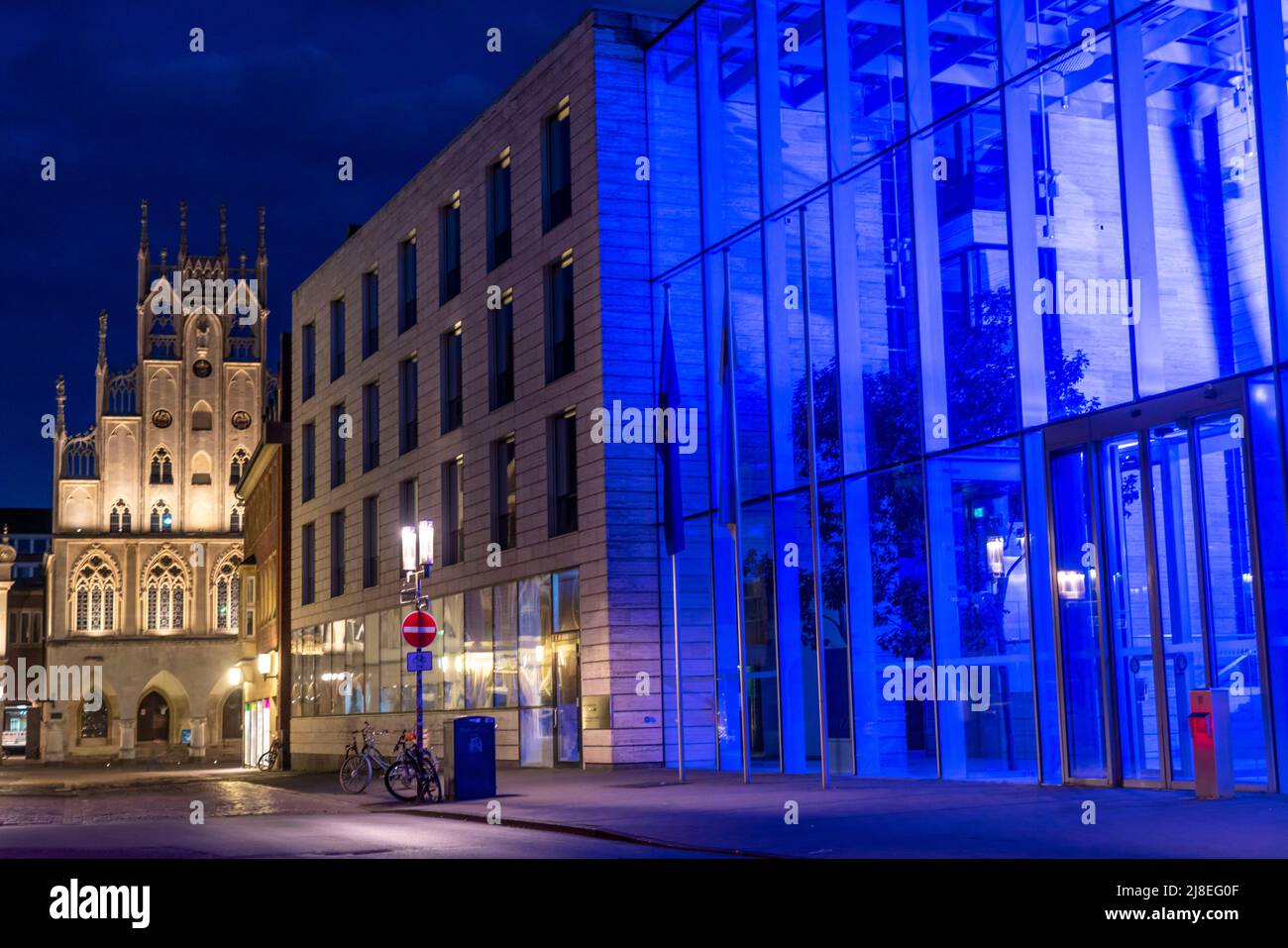 Historische Altstadt, Fassade des historischen Rathauses, blau beleuchtetes Gebäude der Bezirksregierung Münster, beleuchtete Barriere, Poller, in Stockfoto