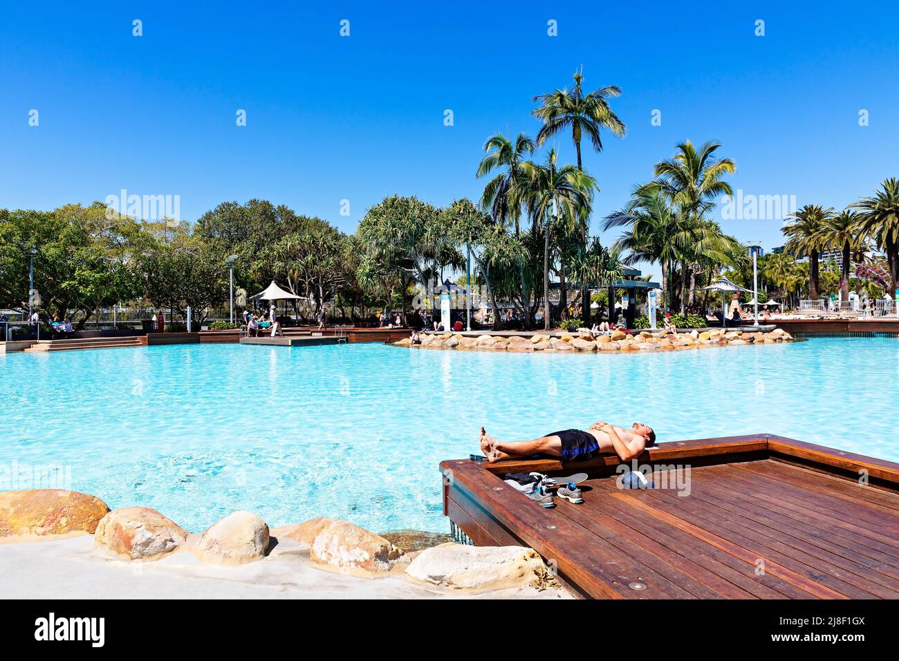 Brisbane Australien / Ein junger Mann genießt die Sonne am Streets Beach ein städtischer Badestrand. Stockfoto