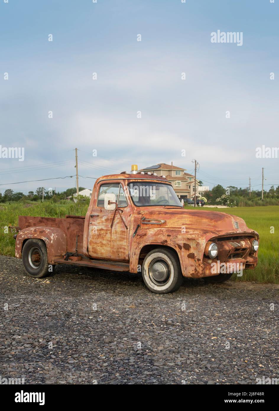 Klassischer alter rostiger Pick-up-Truck, der in einer felsigen Auffahrt in einer Stadt in Subburban geparkt ist Stockfoto