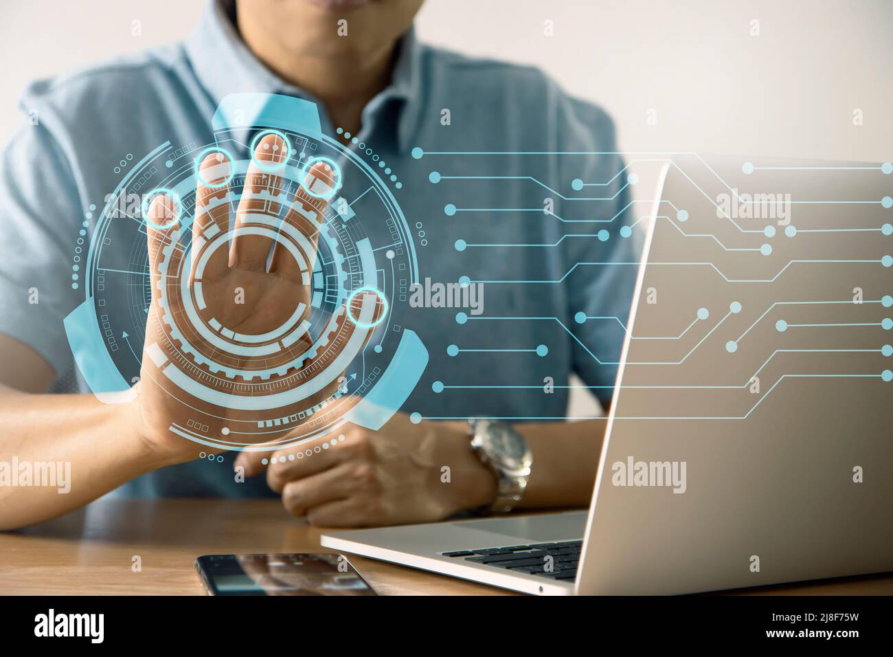 Mann mit Computer-Notebook, der per Handscan auf Geschäftsinformationen über den virtuellen Touchscreen zugreift Stockfoto