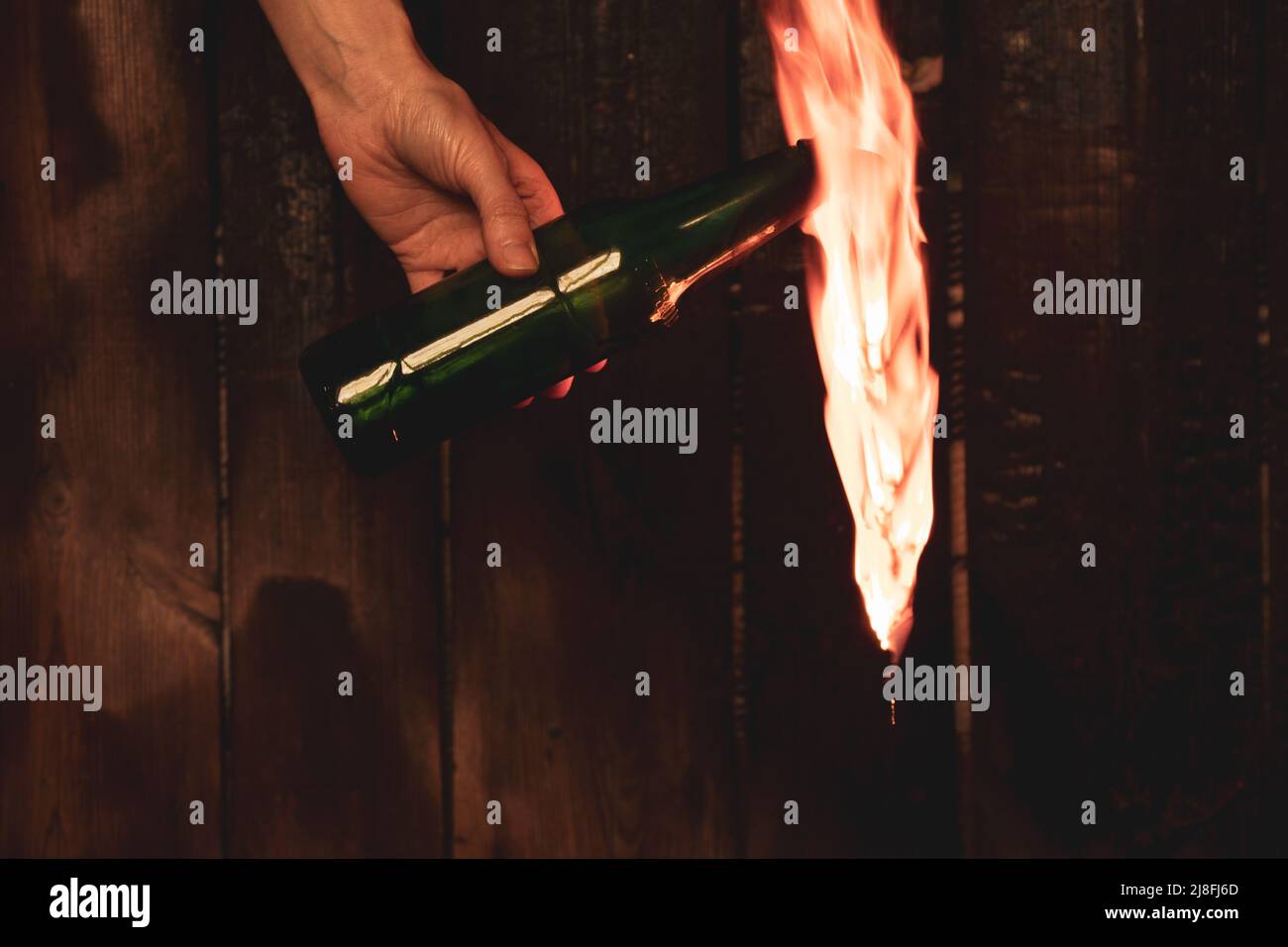 Molotow-Cocktail in den Händen eines Mädchens, Kriegsrecht in der Ukraine, ein Mädchen, das sich bereit macht, ihr Haus zu verteidigen, brennbares Gemisch in Flaschen mit einem Lappen, Stockfoto