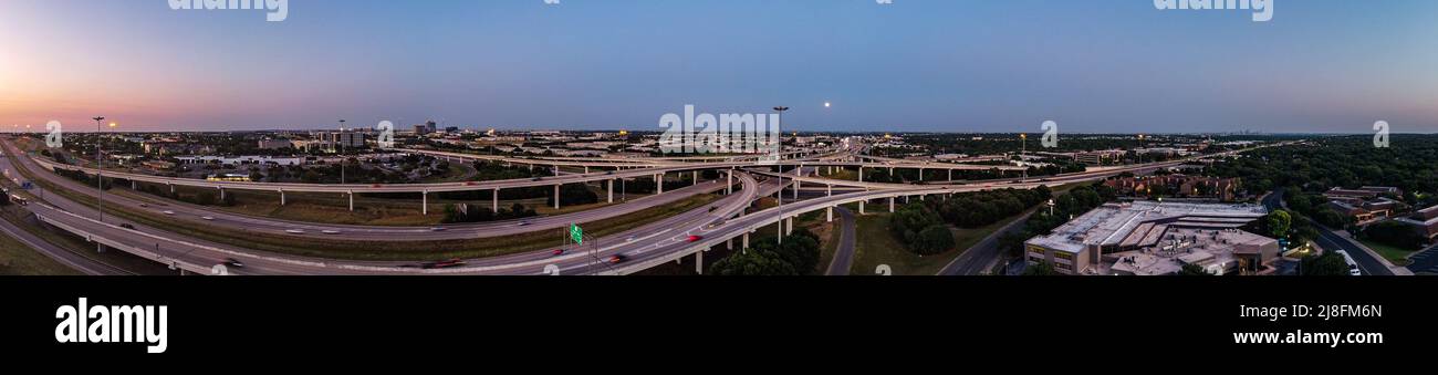 Austin, Texas, USA. 15. Mai 2022. Der Vollmond steigt über der Stadt Austin auf, die 183 North Overpass ist im Vordergrund zu sehen. Dieses erste rote Zeichen stammt vom Sonnenuntergang, aber der Mond am Sonntagabend, dem 15.. Mai, wird als Super Flower Blood Moon bezeichnet. Später an diesem Abend wird es eine Sonnenfinsternis geben, die dem Mond eine rote Farbe verleiht. Er wird Blumenmond genannt, weil im Mai viele Blumen wachsen. Kredit: Sidney Bruere/Alamy Live Nachrichten Stockfoto