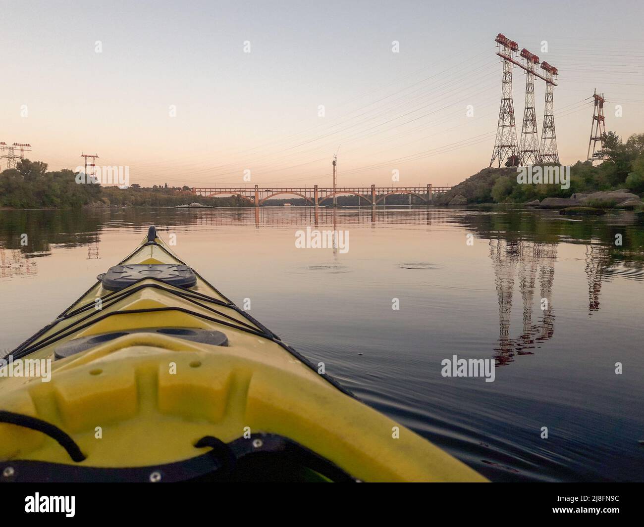 Boote auf dem Fluss bei Sonnenuntergang. Strom Turm und Brücke auf Hintergrund. text Raum. Urlaub. Reisen Stockfoto