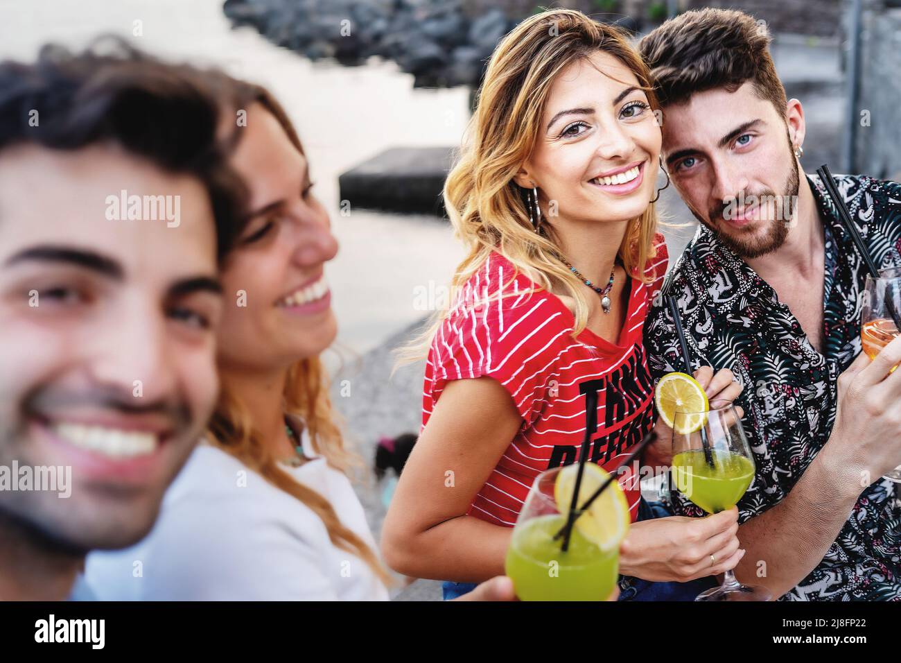 Fröhliche Liebespaare sorglos am Meer trinken Fruchtcocktails und nehmen Selfies Blick auf die Kamera - Lifestyle-Konzept von Freunden hängen in der Stockfoto
