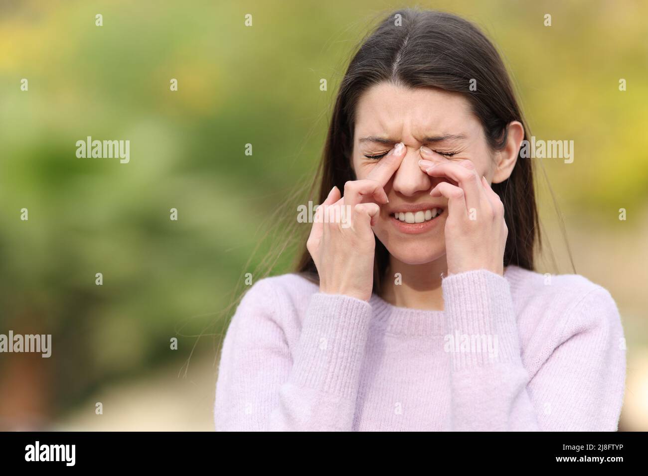 Teenager kratzen juckende Augen beschweren sich im Freien in einem Park Stockfoto
