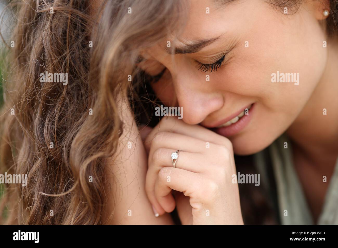 Traurige Frau nach der Verlobung, die sich alleine beschwert und einen Ring zeigt Stockfoto
