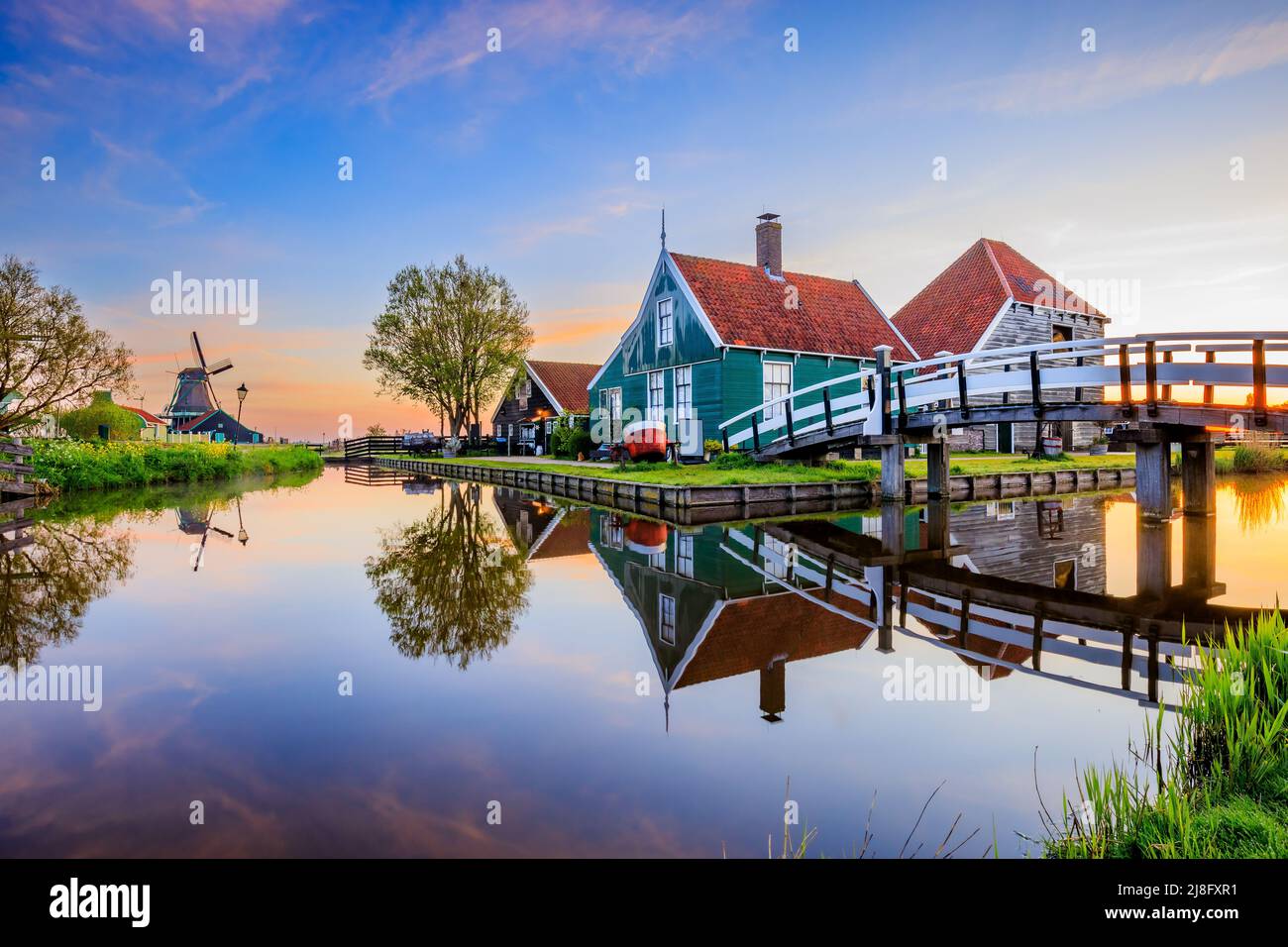 Zaanse Schans Dorf, Niederlande. Niederländische Windmühle und traditionelles Haus bei Sonnenaufgang. Stockfoto