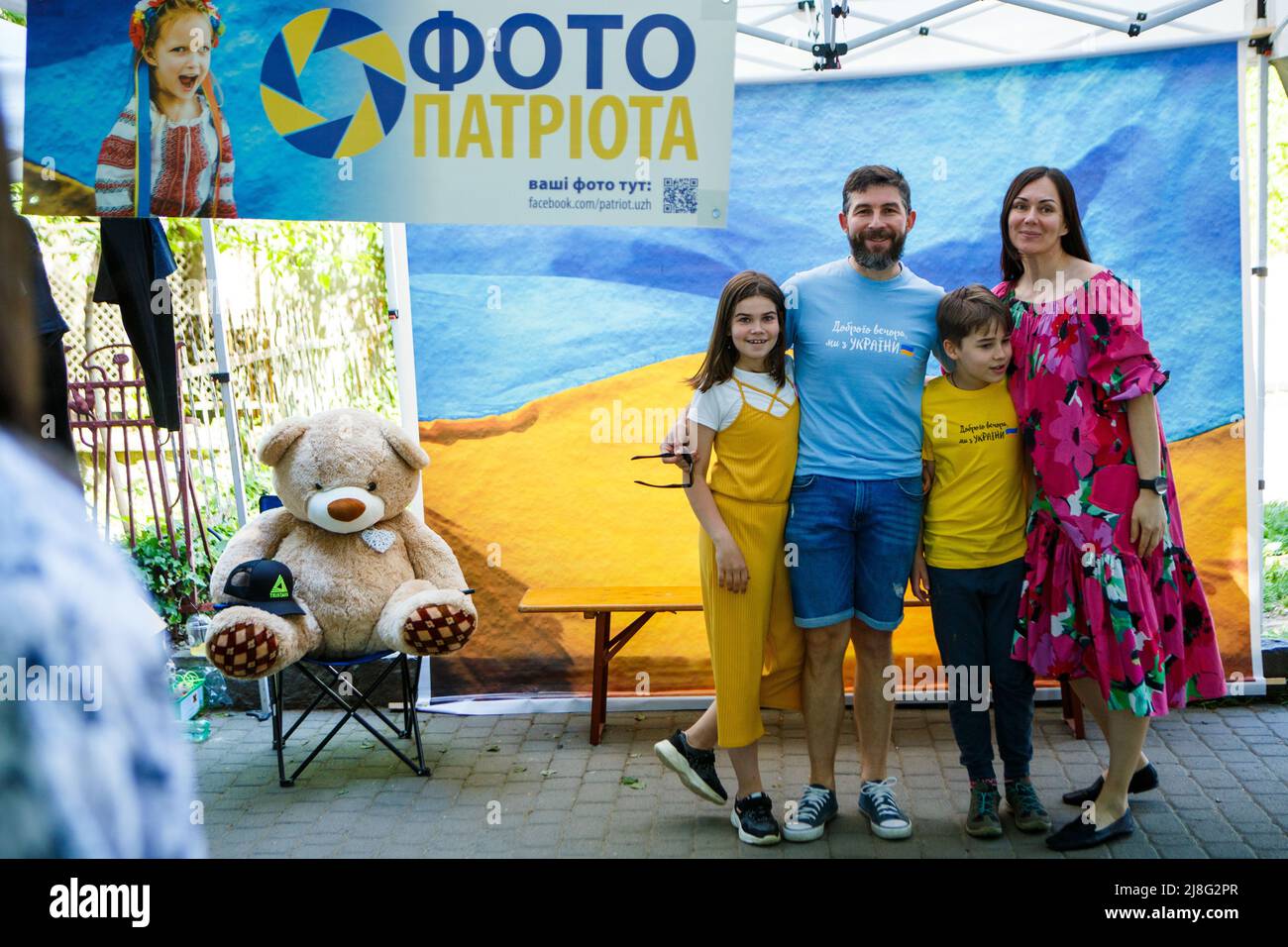 Nicht exklusiv: UZHHOROD, UKRAINE - 14. MAI 2022 - Eine Familie posiert für ein Foto, während lokale Fotografen die Porträts von Menschen vor dem Hintergrund machen Stockfoto
