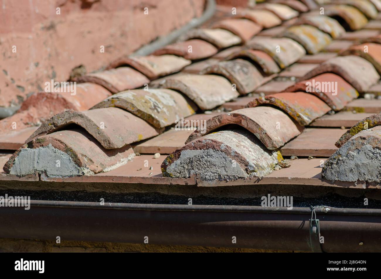 Haus: Gebäude mit Dachschräge mit Ziegelsteinen, Dachrinne aus freiliegendem Blech. Die Schindeln sind aus Lehm, mit einer selbstsichernden Form. Stockfoto