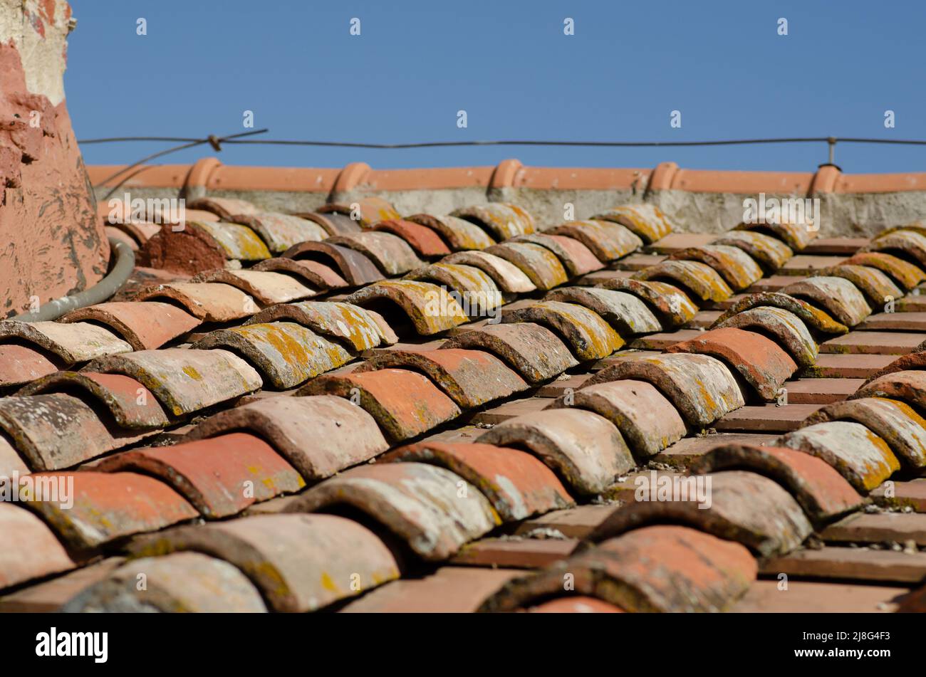 Haus: Schräge Dächer mit Ziegelsteinen, freiliegende obere Kante und Kacheln. Die Schindeln sind Ton oder Terrakotta, ein altes Design von gebogenen. Stockfoto