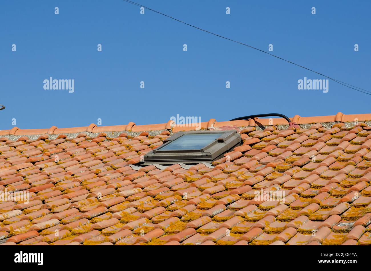 Haus: Schräge Dächer mit Ziegelsteinen, freiliegende obere Kante und Kacheln. Die Fliesen sind aus Ton, Randplatte. Stockfoto