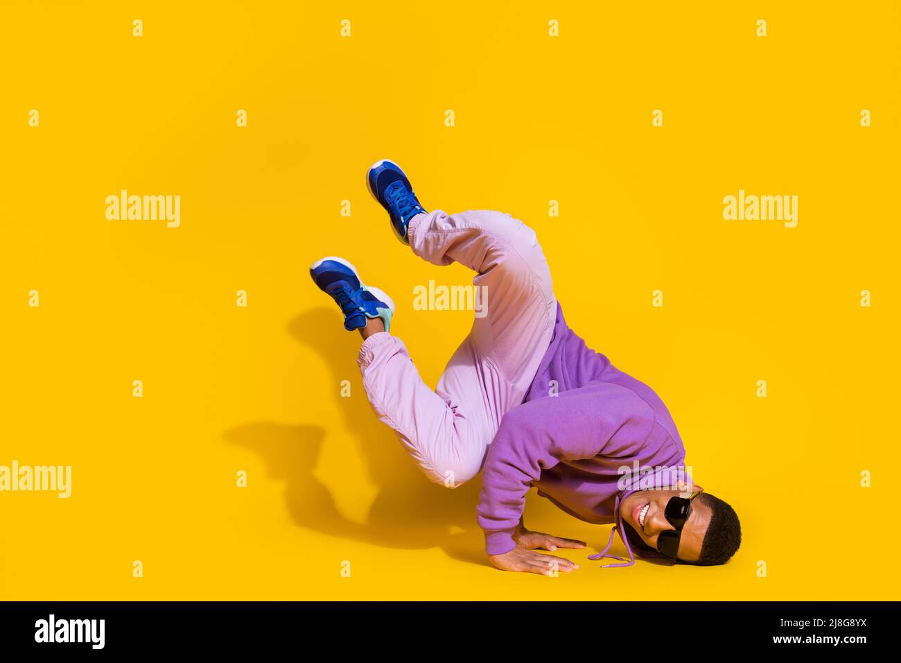In voller Länge Körpergröße Ansicht der attraktiven trendigen Kerl tanzen niedrige Bremse Training isoliert auf hellen gelben Hintergrund Stockfoto