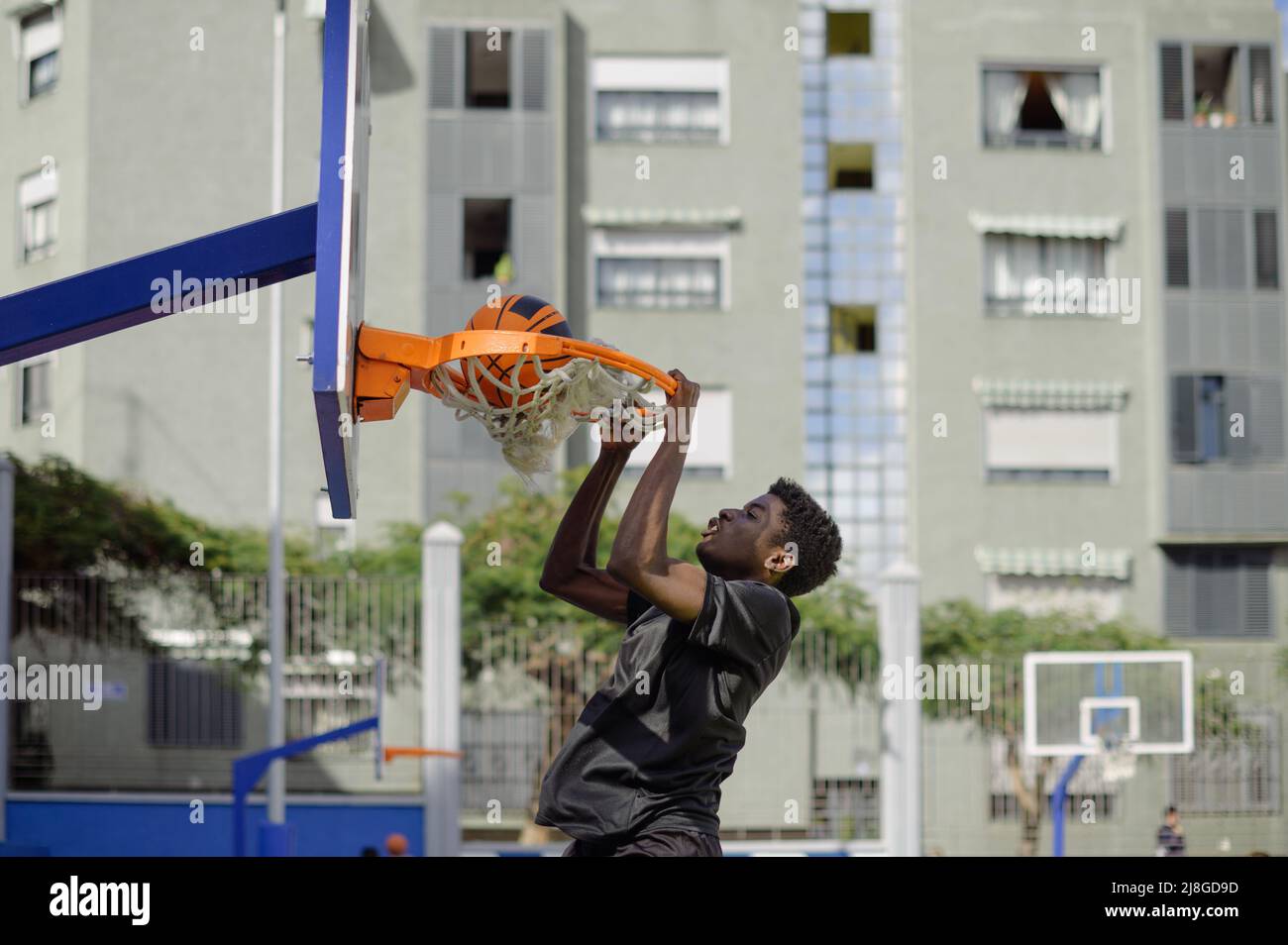 Schwarzer Mann, der beim Basketball Slam Dunk spielt Stockfoto