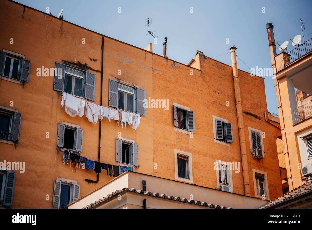 Italienisches Haus mit Fenstern mit Rollläden und Wäschestauken am Seil unter den Fenstern Stockfoto