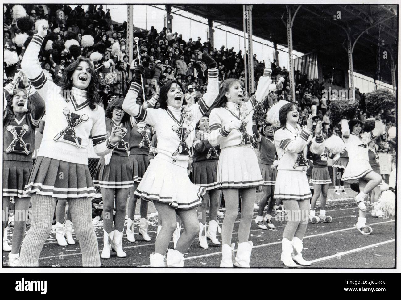 Verdreher und Cheerleader der Lincoln High School reagieren auf einen Touchdown in einem Spiel gegen Midwood High auf dem Midwood Field in Brooklyn, New York, um 1980. Stockfoto