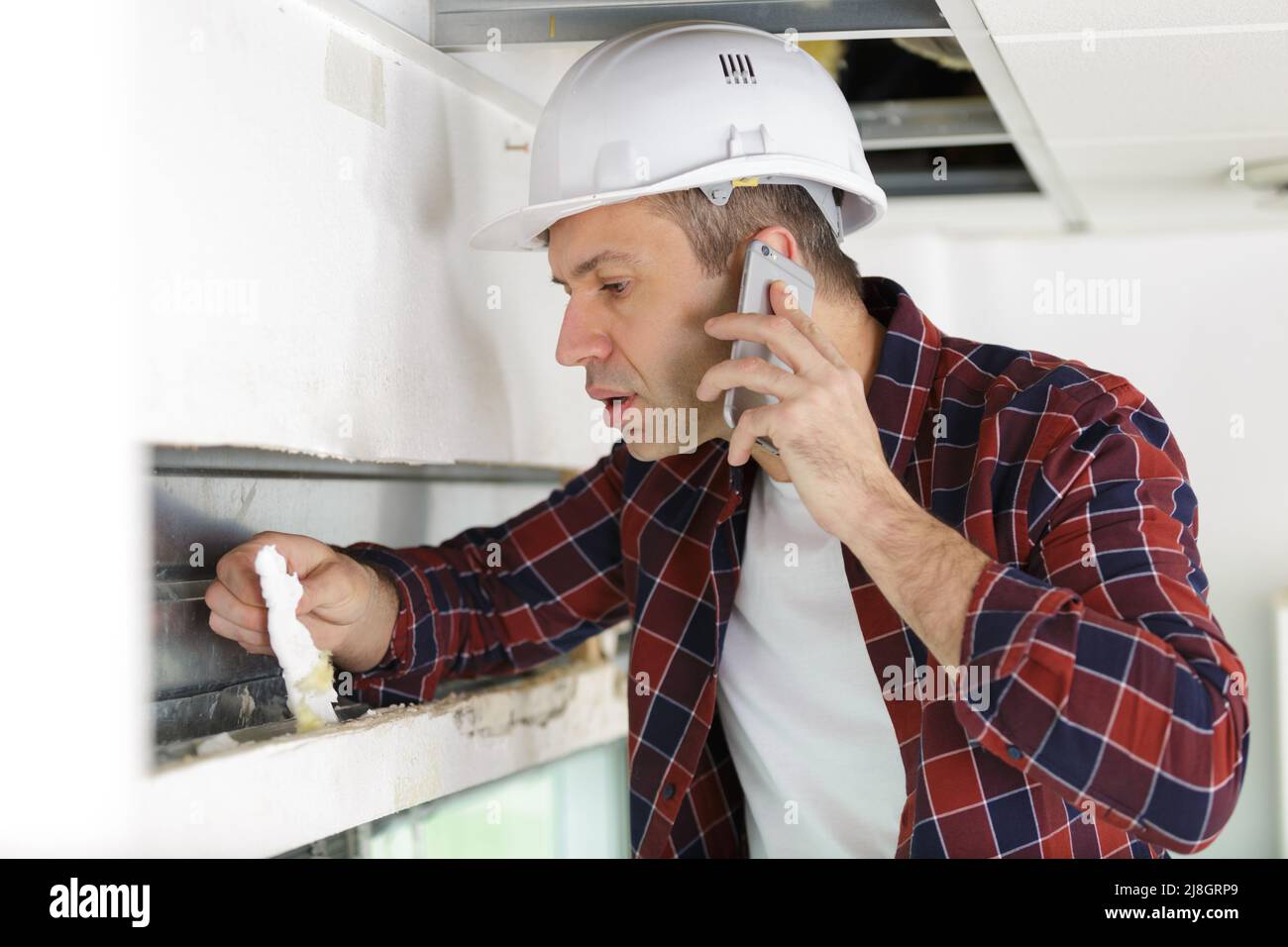 baumeister am Telefon während der Renovierung der Wohnung Interieur Stockfoto