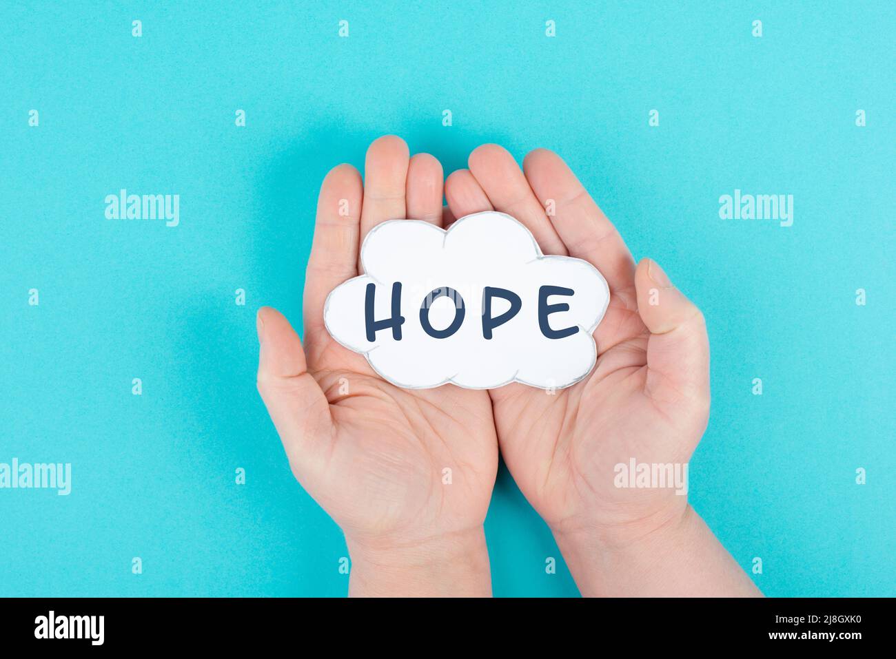 Halten Sie eine Wolke mit dem Wort Hoffnung in den Händen, Vertrauen und glauben Konzept, Vertrauen in die Zukunft, hoffnungsvoll positive Denkweise Stockfoto