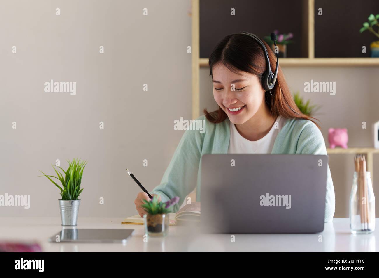 Lächelnder asiatischer aufmerksamer Student studiert Online-Klasse. E-Learning-Bildungskonzept. Stockfoto