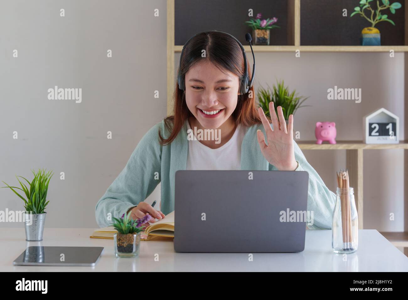 Lächelnder asiatischer aufmerksamer Student studiert Online-Klasse. E-Learning-Bildungskonzept. Stockfoto