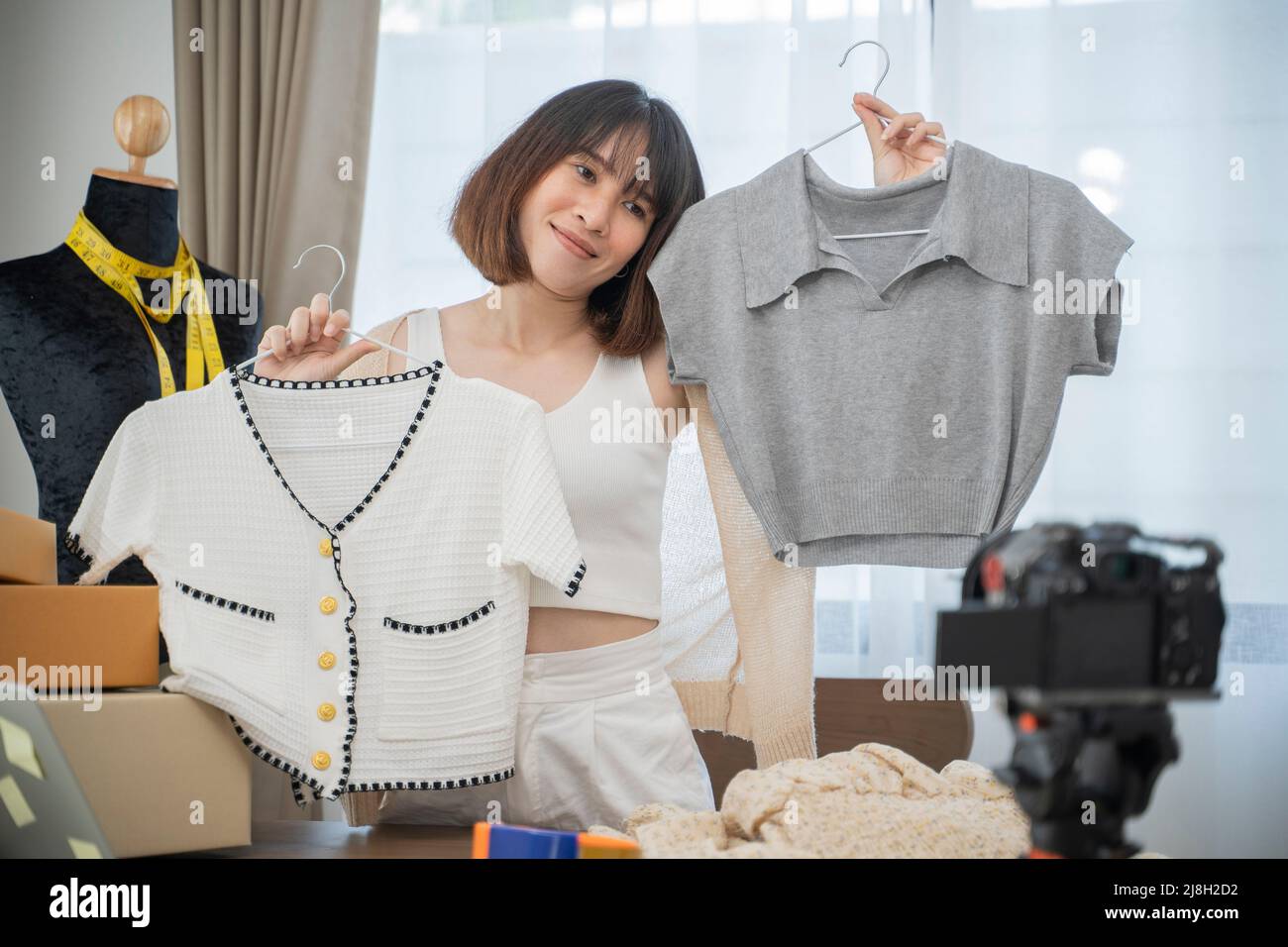 Junge Frau arbeitet live Streaming Online-Bekleidungsgeschäft zu Hause. Stockfoto