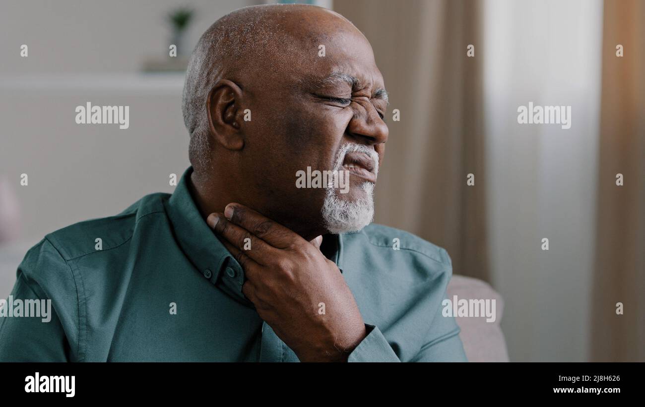 Kranke afrikanische alte Mann leiden an Halsschmerzen schmerzhafte Mandelentzündung Reizung Senior männlichen Indoor Check Drüse Laryngitis bakterielle Infektionen Krankheiten Stockfoto