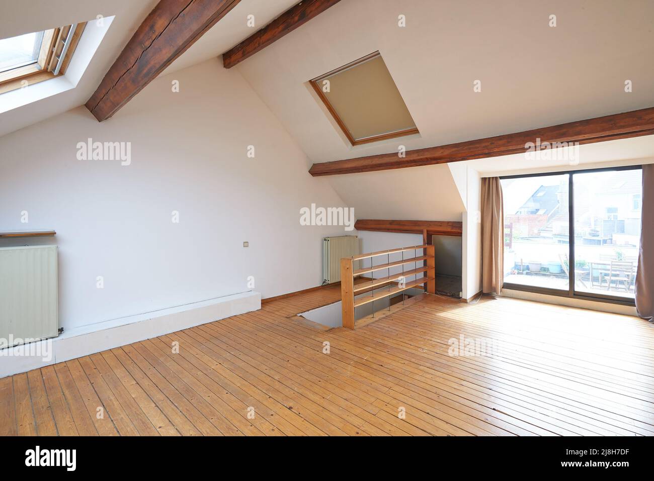 Innenfenster im Dachgeschoss und Holzboden im leeren Raum Stockfoto