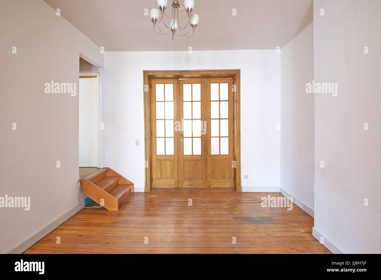 Innen gealterte Holztür mit Glasrahmen im leeren Raum Stockfoto