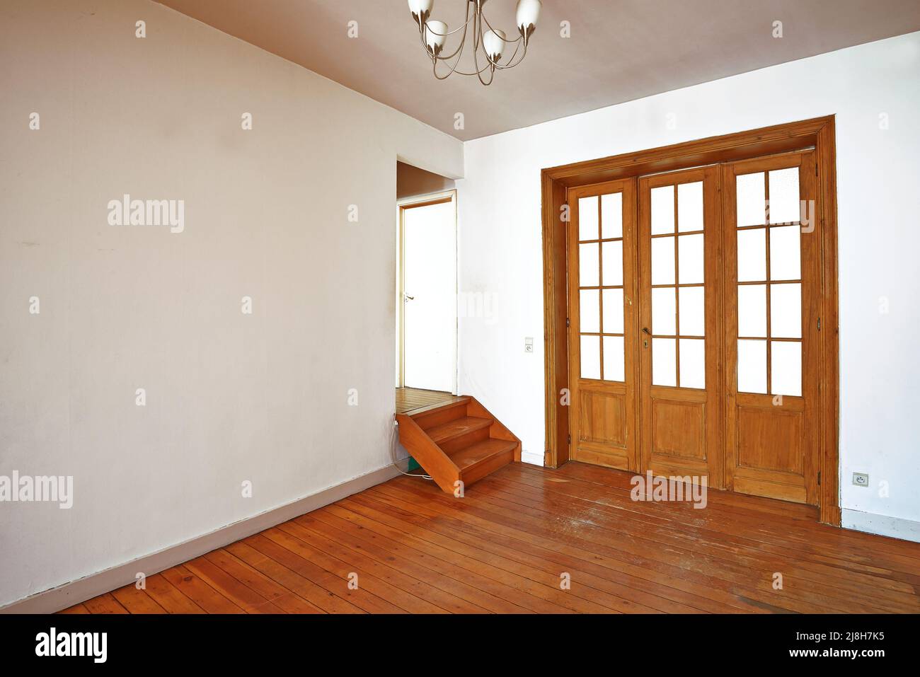 Innen gealterte Holztür mit Glasrahmen im leeren Raum Stockfoto