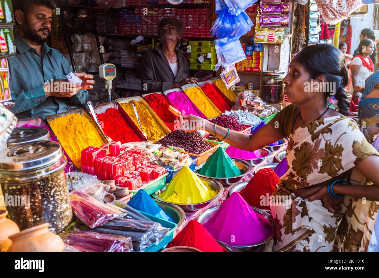 Mysore, Karnataka, Indien : Eine Frau kauft an einem Stand auf dem Devaraja-Markt kumkumumfarbenes Pulver, das für Bindi-Punkte verwendet wird. Stockfoto