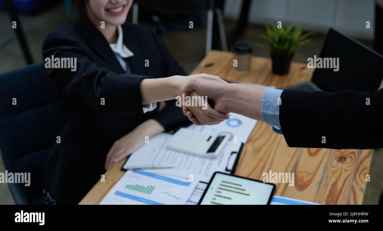 Zwei Geschäftsleute schütteln sich die Hände, nachdem sie gemeinsam einen Geschäftsvorschlag angenommen haben, ein Händedruck ist eine universelle Hommage, die oft zum Gruß oder verwendet wird Stockfoto