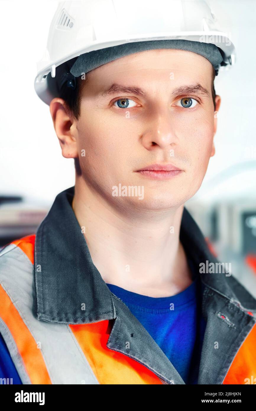 Porträt eines jungen kaukasischen Ingenieurs in weißem Helm und Schutzweste. Mitarbeiter der Gasindustrie in der Produktionsanlage.reale Szene. Stockfoto