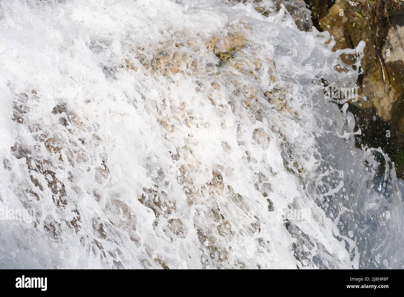 Der Fluss-Wasserfall-Strom fließt über moosige Steine Stockfoto
