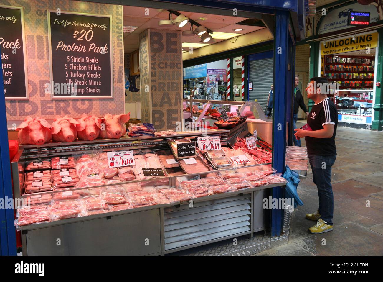 LEEDS, Großbritannien - 12. JULI 2016: Menschen besuchen den Metzgerstand auf dem Leeds Kirkgate Market in Großbritannien. Es gibt 800 Stände auf dem Markt. Es wird von 100.000 besucht Stockfoto