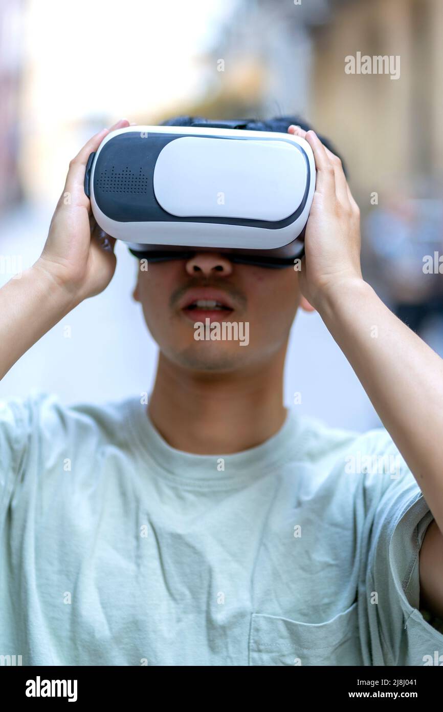 Junger asiatischer Mann mit seiner Virtual-Reality-Brille Stockfoto