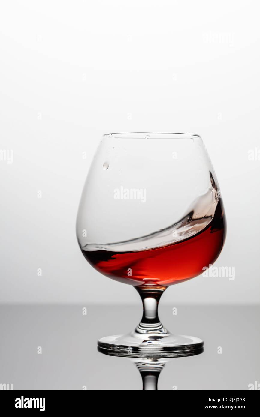 Splash of Brandy in einem snifter Glas. Speicherplatz kopieren. Stockfoto