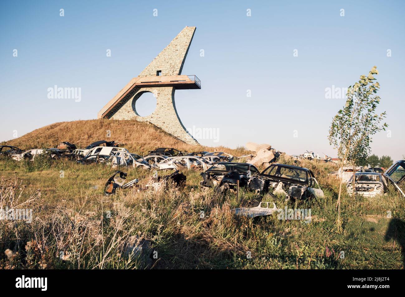 Schrottplatz, Autodumpe, Metallschrott. Ein Haufen beschädigter, zerbrochener, rostiger Autos wuchs mit Gras in der Nähe des größten Sees des kaukasus, Sevan, in den Vororten von Stockfoto