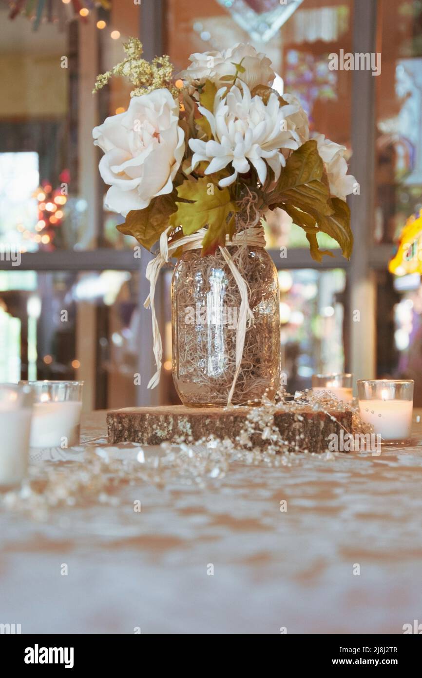 Stillleben Tischdekoration, Kleines Herzstück, Blumen, Twinkle Lights, Kerzen Stockfoto