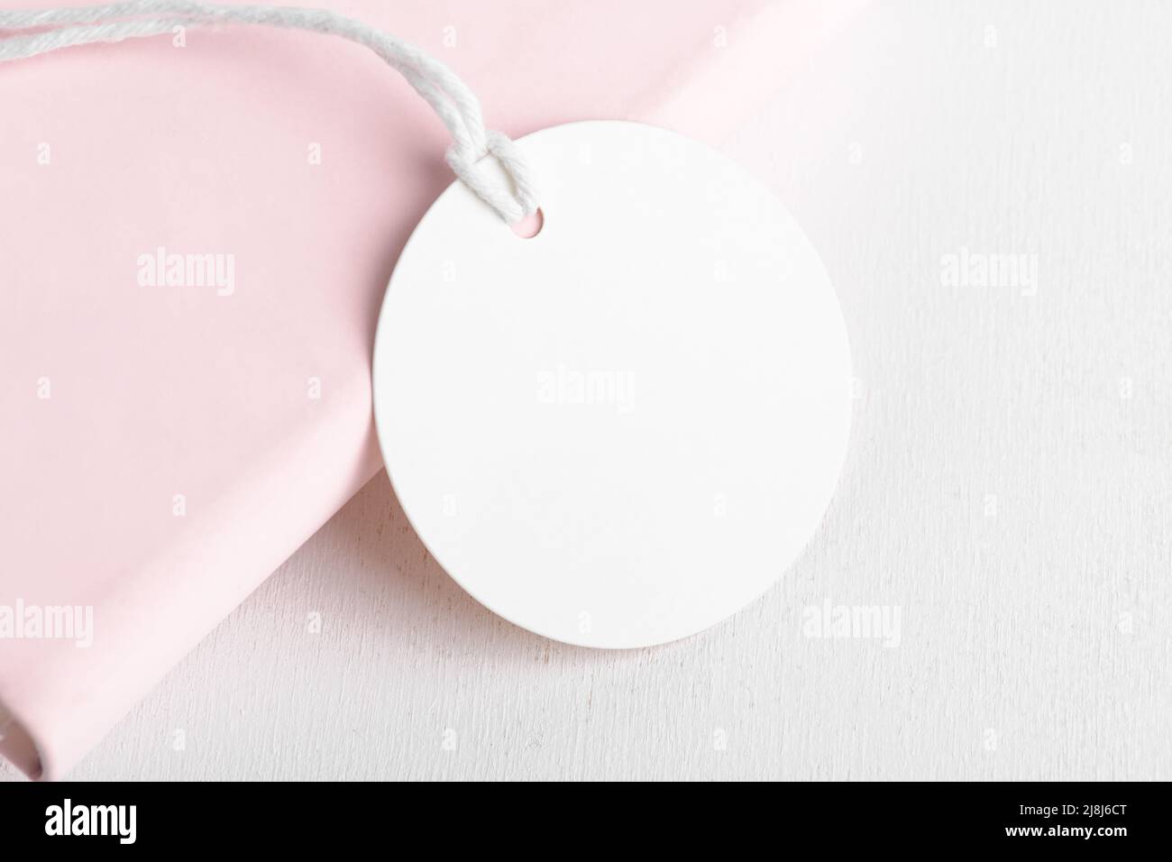 Rundes weißes Geschenkanhänger-Modell auf rosa Hintergrund. Blankopapier kreisförmigen Preis Aufkleber Tag mockup, Sale und Black Friday Konzept, Element für Design, labe Stockfoto