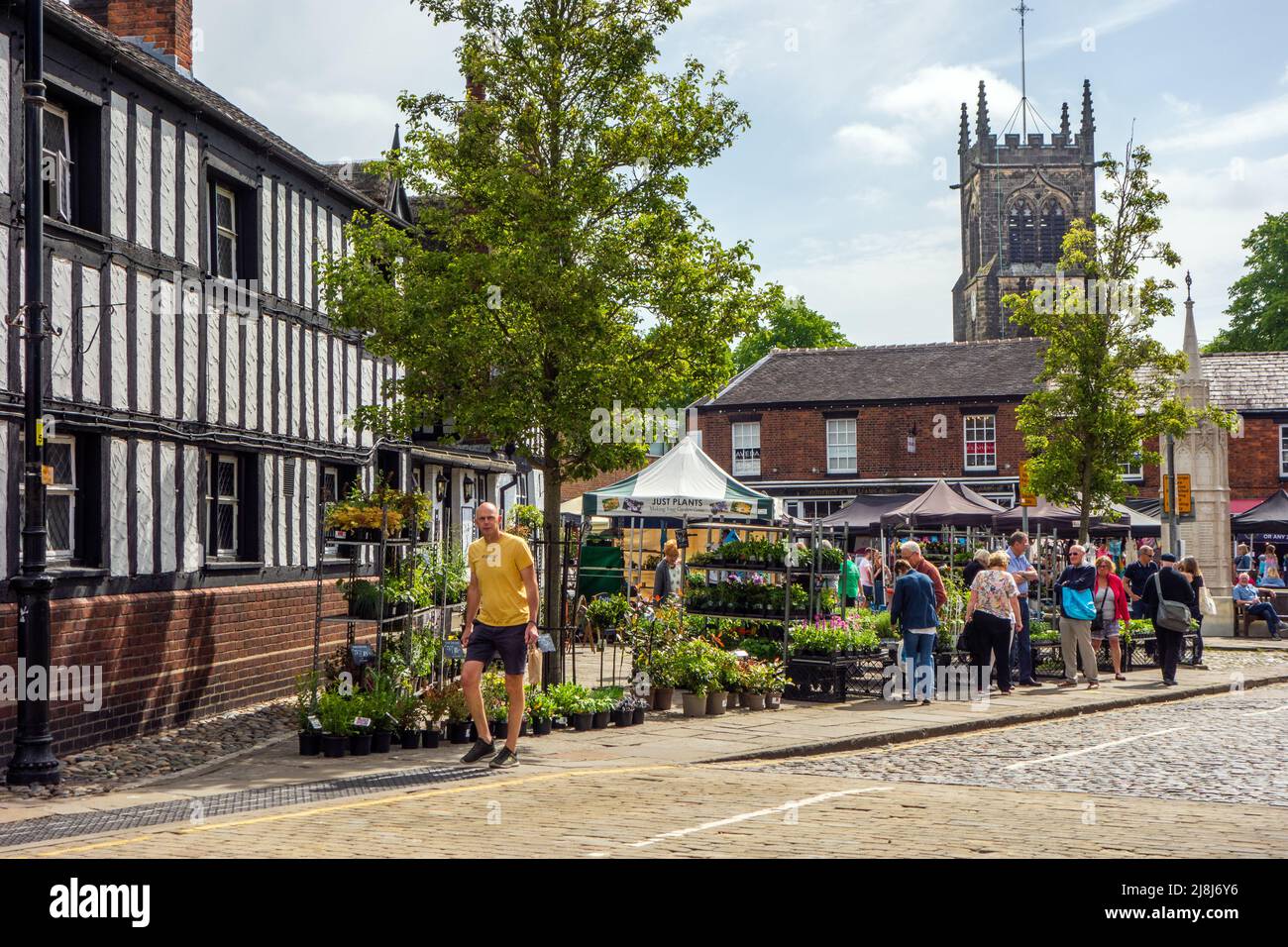 Menschen vor dem Black Bear Inn am Bauern- und Makermarkt auf dem alten Marktplatz der Marktstadt Sandbach in England Stockfoto