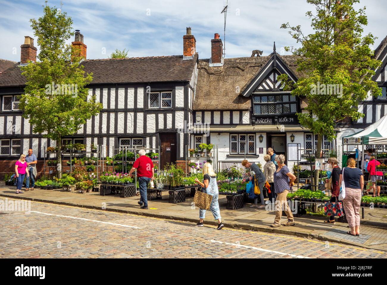 Menschen vor dem Black Bear Inn auf dem Bauernmarkt auf dem alten Marktplatz der Marktstadt Sandbach in England Stockfoto