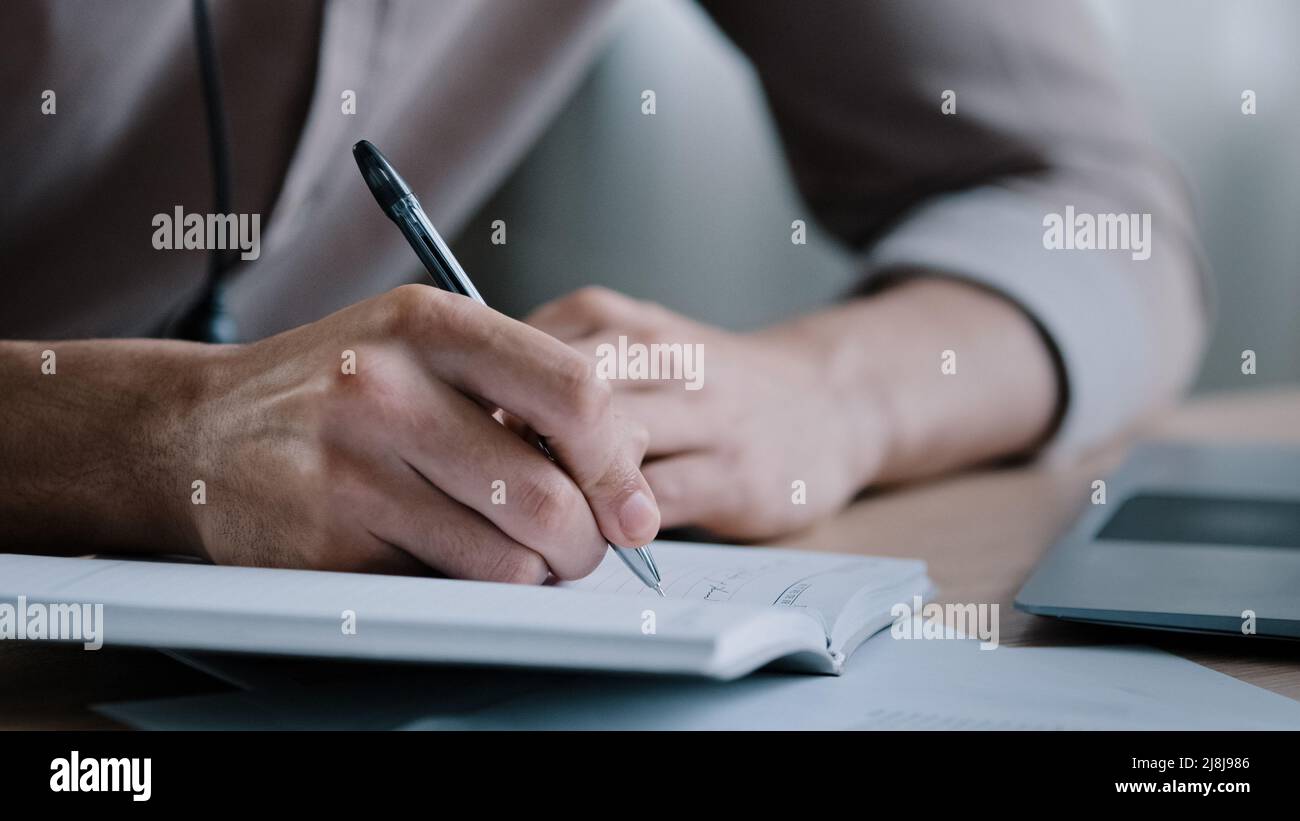 Nahaufnahme unbekannt rechtshändigen männlichen Geschäftsmann schreiben Notizen Geschäftsideen beim Veranstalter Schriftsteller sitzen zu Hause Büro halten Stift Nachricht Informationen Aufgaben in Stockfoto