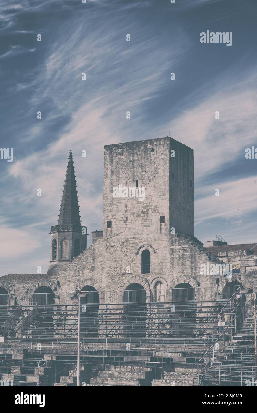 Arles Amphitheater (erbaut 90 n. Chr.). Die Türme auf der Spitze sind mittelalterliche Extras. Im Hintergrund der Glockenturm von Église Couvent des Cordeliers. Arles. Stockfoto
