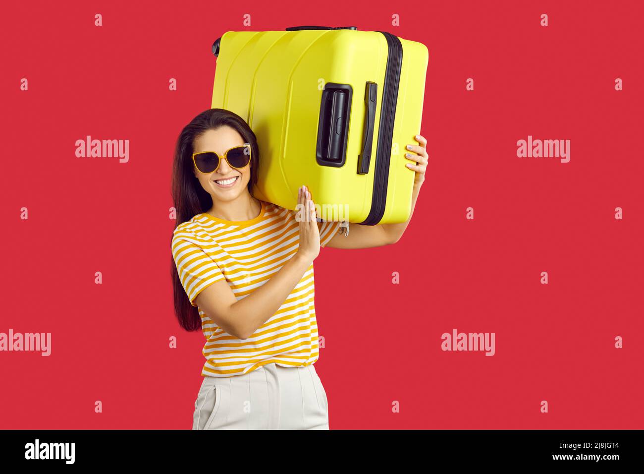 Lächelnde Frau mit Koffer fahren in den Urlaub Stockfoto