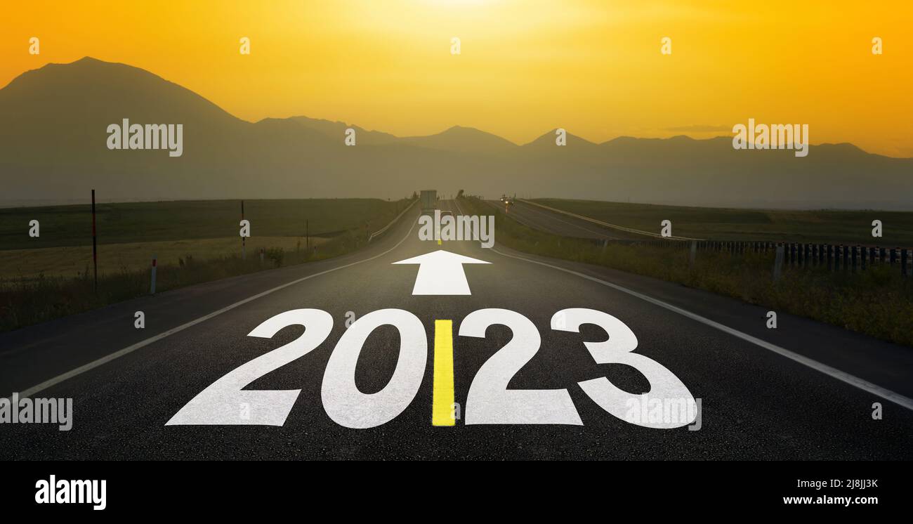 Die Schrift des Jahres 2023 auf der langen Asphaltstraße. Panorama-Banner für das Jahr 2023. Abendansicht auf flacher Straße für Hoffnung und Zukunftsplan-Konzept. Stockfoto