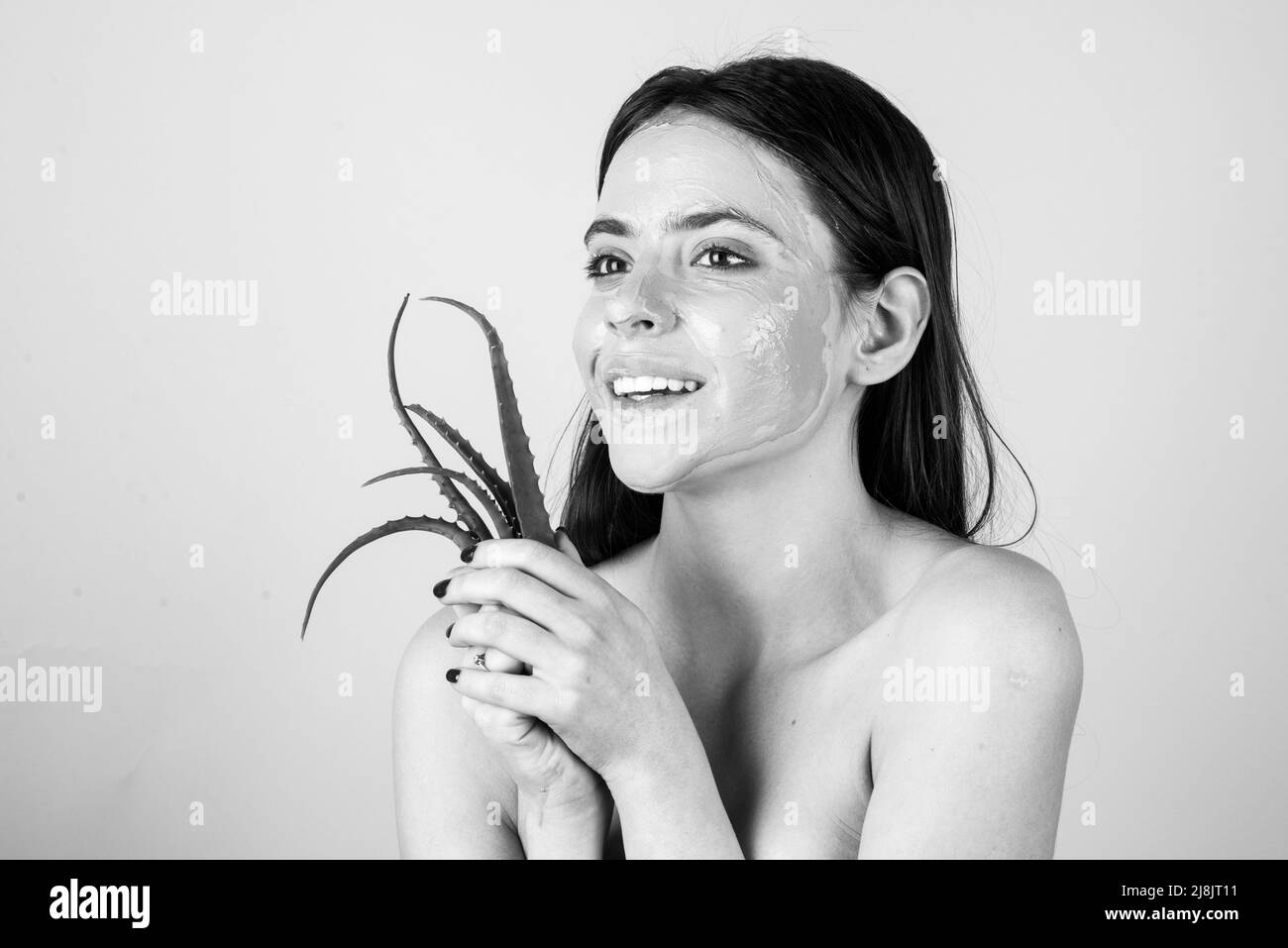 Schöne Frau mit Aloe Vera Gesichtsbehandlung, Wellness-Konzept. Hautpflege Schönheitsbehandlung. Handtuch auf dem Kopf. Medizinischer Mineralschlamm. Stockfoto