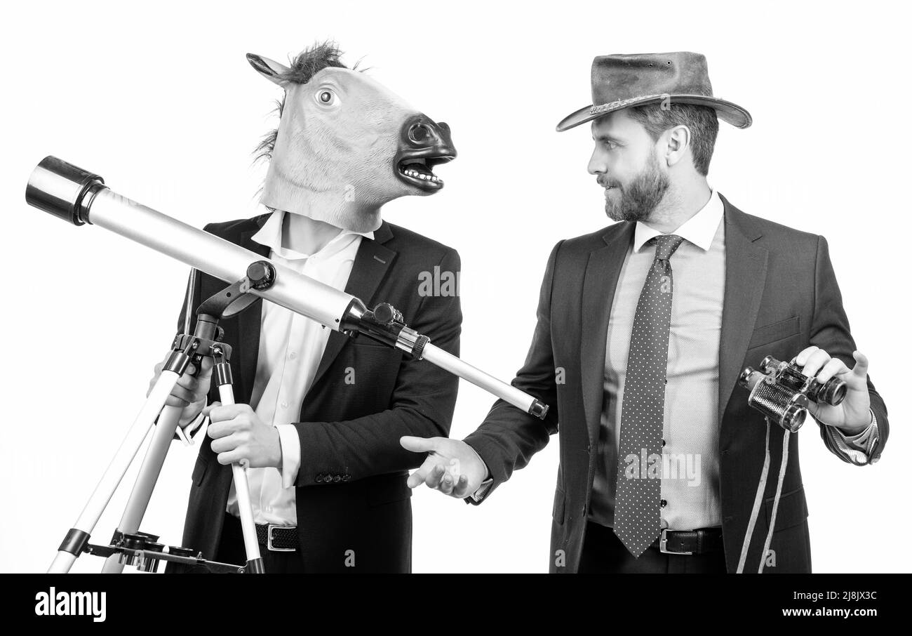Geschäftsmann in Pferdekopfmaske halten Teleskop und Cowboy Mann mit Fernglas, Business Vision Stockfoto