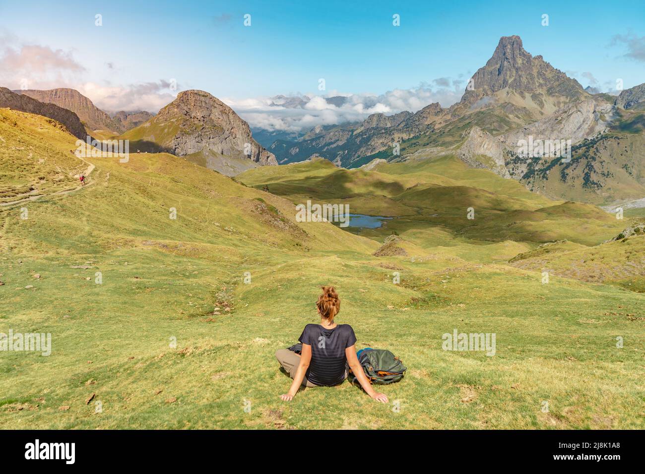 Junge attraktive Frau, die im Sommer in einer wunderschönen wilden Berglandschaft sitzt. Discovery Travel Destination Konzept. Stockfoto