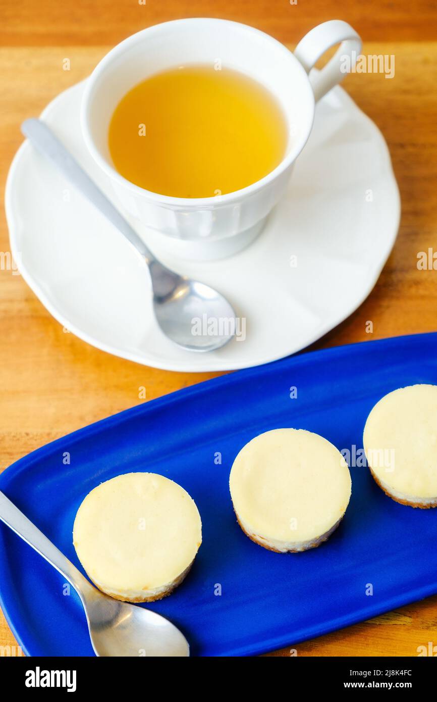 Kleine runde Käsekuchen, serviert mit einer Tasse Tee Stockfoto