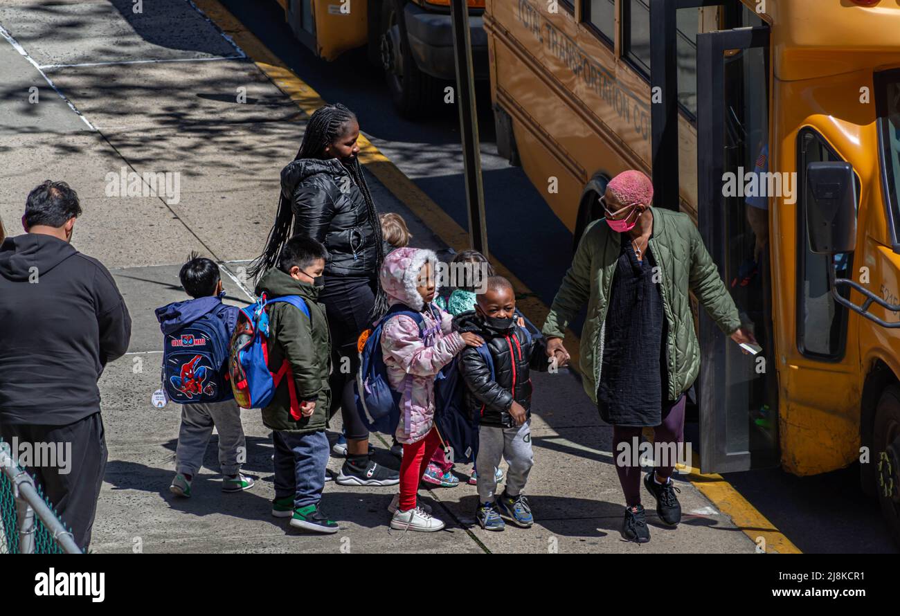 Pre-K Kinder und ein Lehrer steigen in einen Schulbus ein Stockfoto